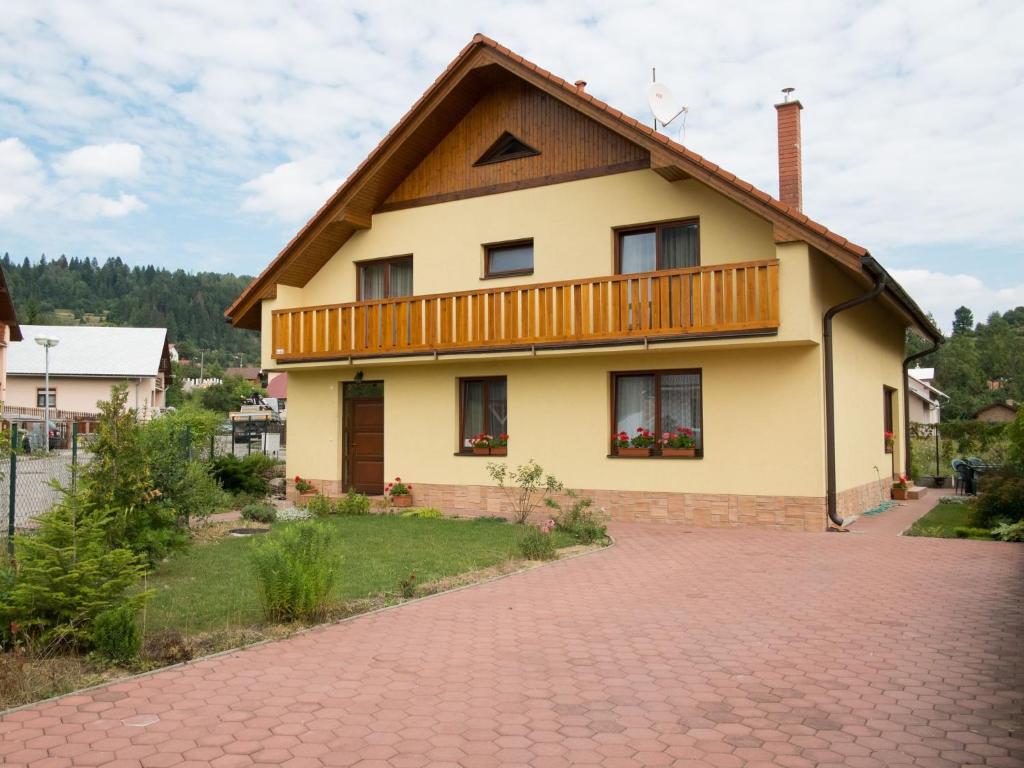 una casa con balcone e vialetto di mattoni di Žltý Dom a Terchová