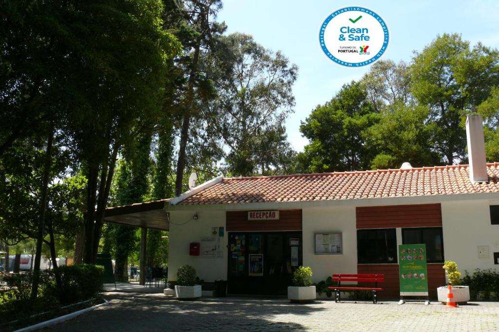 un edificio con un banco rojo delante de él en Parque de Campismo Orbitur Caminha, en Caminha