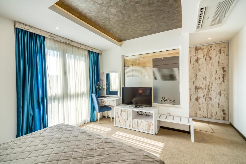 a bedroom with a bed and a television on a table at Boutique Hotel "Salina" in Ulcinj