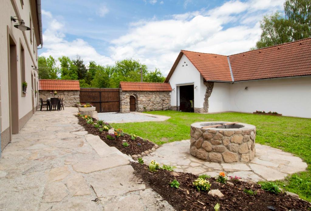 een achtertuin met een stenen vuurplaats en een gebouw bij Residence Klažary u Žumberka in Kamenná