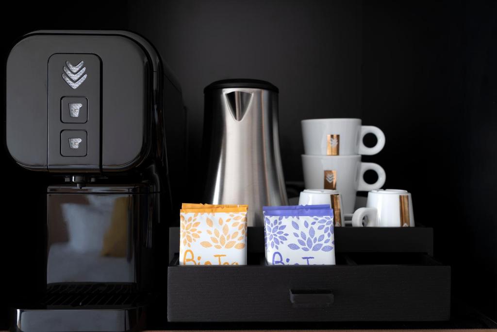 a black shelf with cups and a vase at Hôtel Villa KOEGUI Bayonne in Bayonne