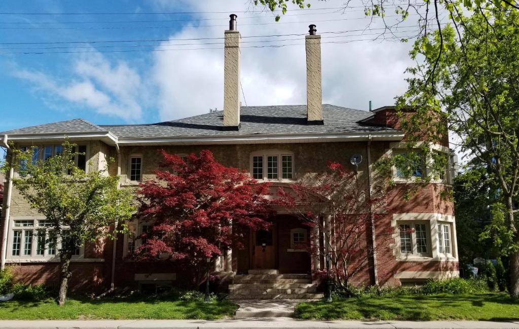 an old house with two chimneys on top of it at The Jane Toronto in Toronto