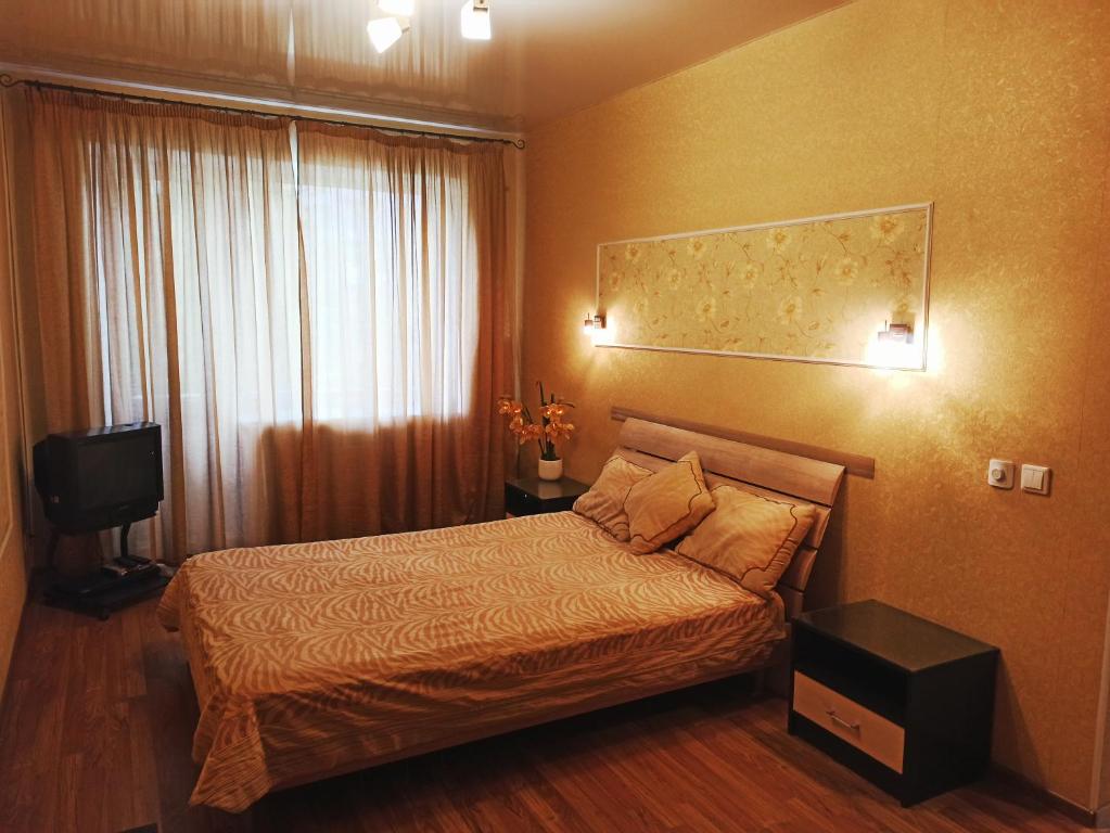 ヤロスラヴリにあるApartment on prospekt Lenina 53のベッドと窓が備わるホテルルーム