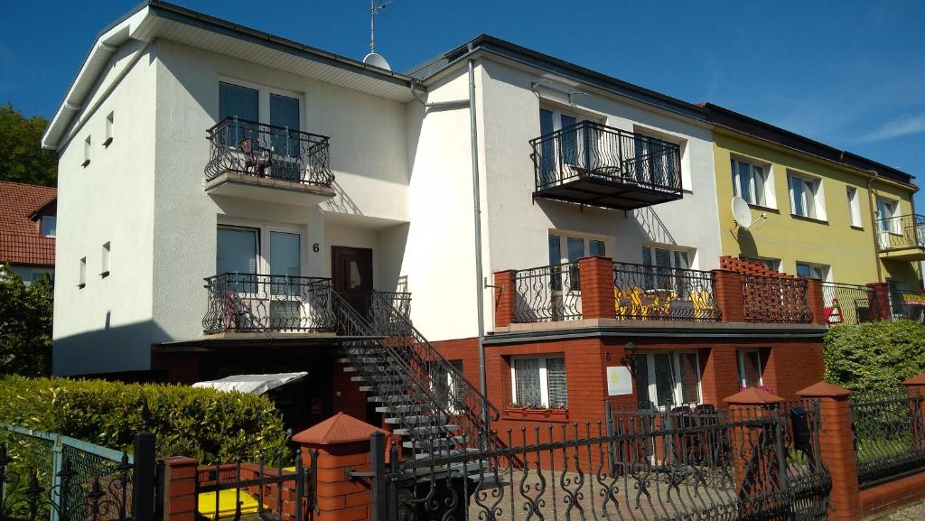 un edificio blanco con balcones en un lateral en Villa Selavi en Kołobrzeg