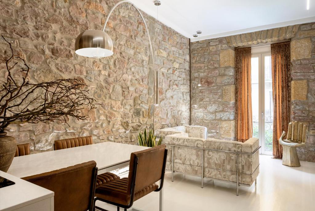 a dining room with a table and a stone wall at Spectacular by Sebastiana Group in San Sebastián