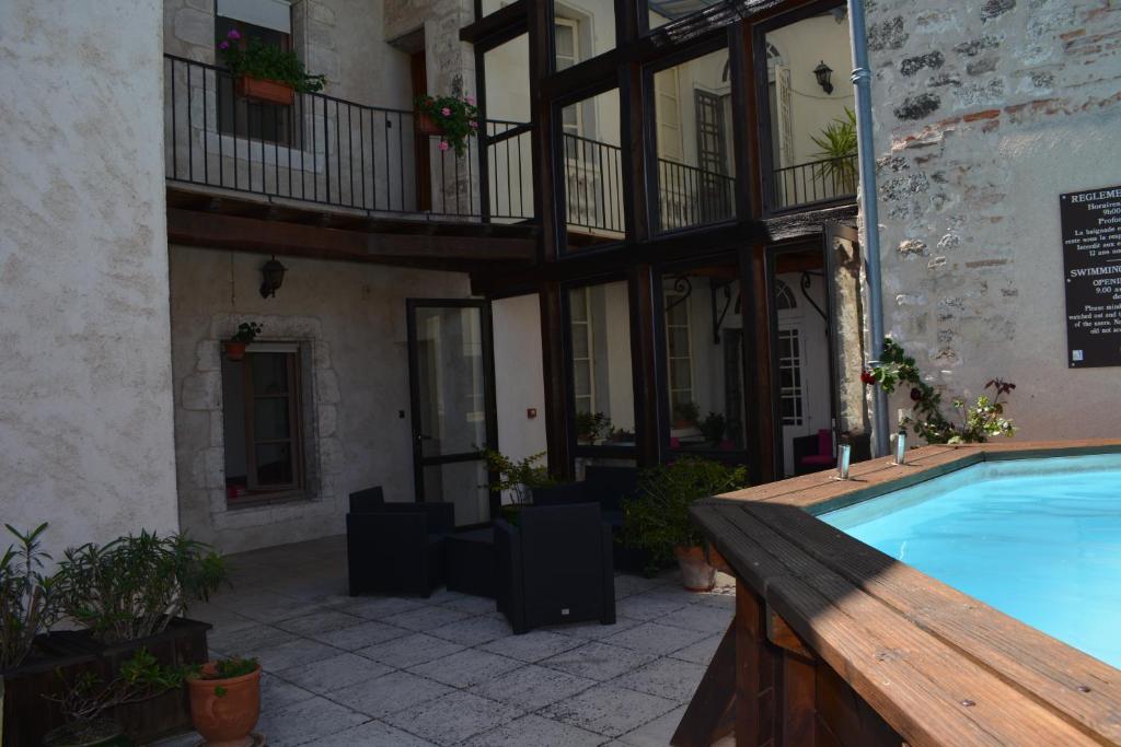 uma piscina em frente a um edifício em Hotel des Consuls em Castelnau-de-Montmiral