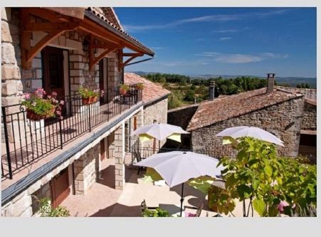 a group of white umbrellas sitting on a balcony at Aux Vieux Arceaux in Mercuer