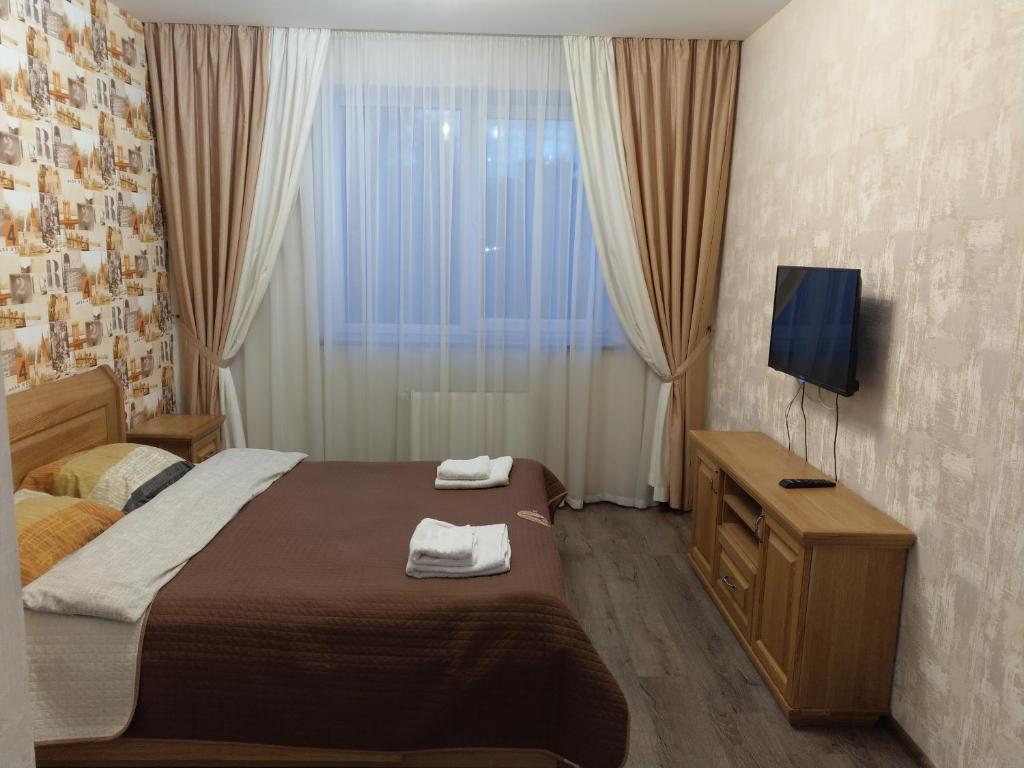 - une chambre avec un lit, une télévision et une fenêtre dans l'établissement однокімнатна квартира в новобудові по Мельника, à Rivne