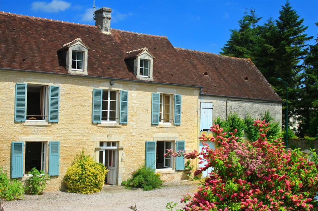 uma velha casa de tijolos com persianas azuis e flores em Maison de 3 chambres avec vue sur la ville jardin clos et wifi a Ri em Ri