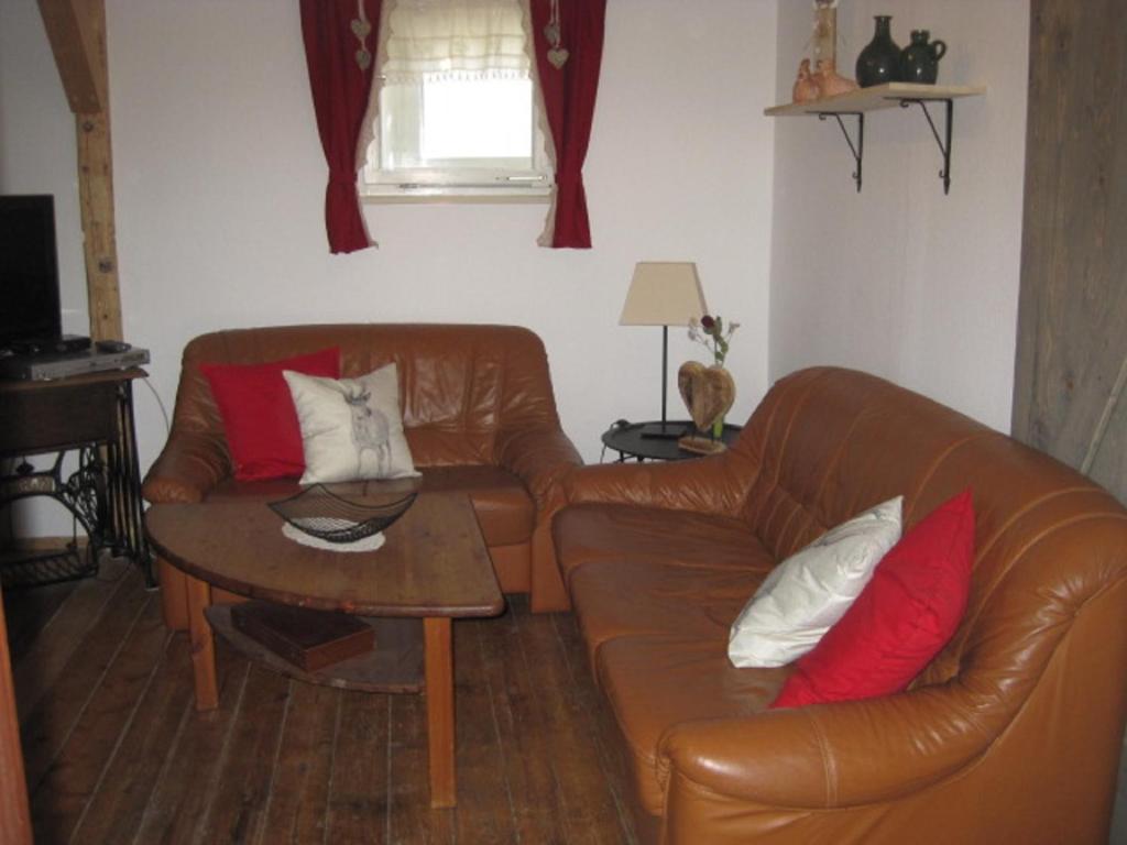 a living room with a leather couch and a table at Ferienhaus Becker in Rödental