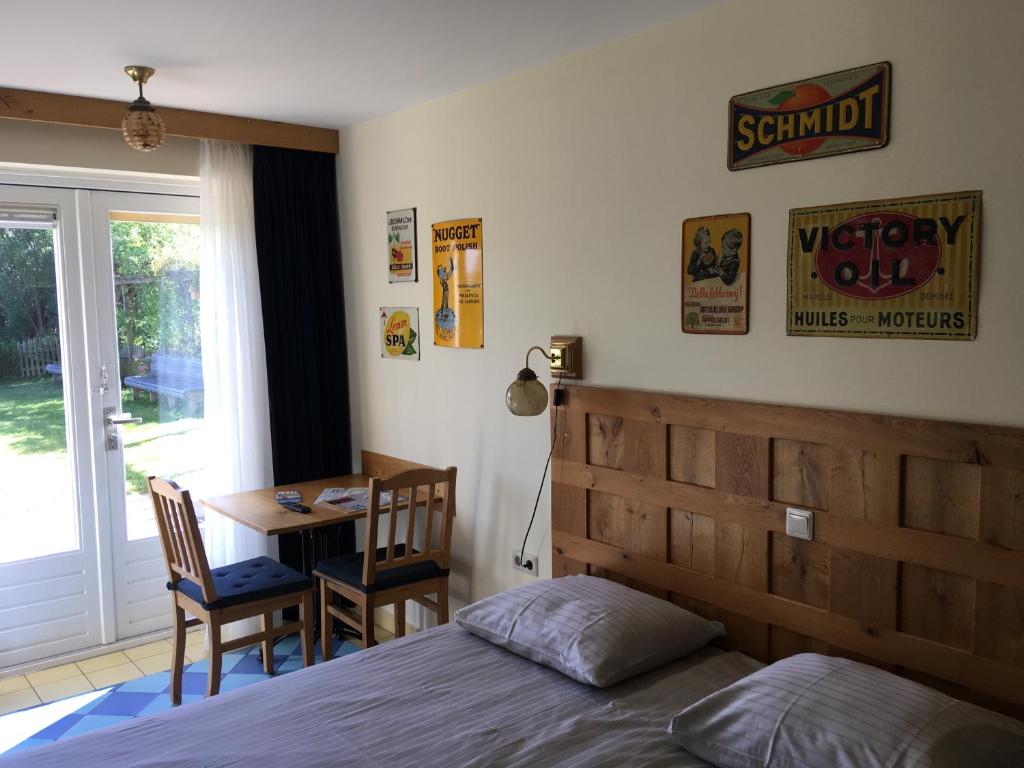 een slaapkamer met een bed, een bureau en een tafel bij Carels Kamers Texel in De Koog