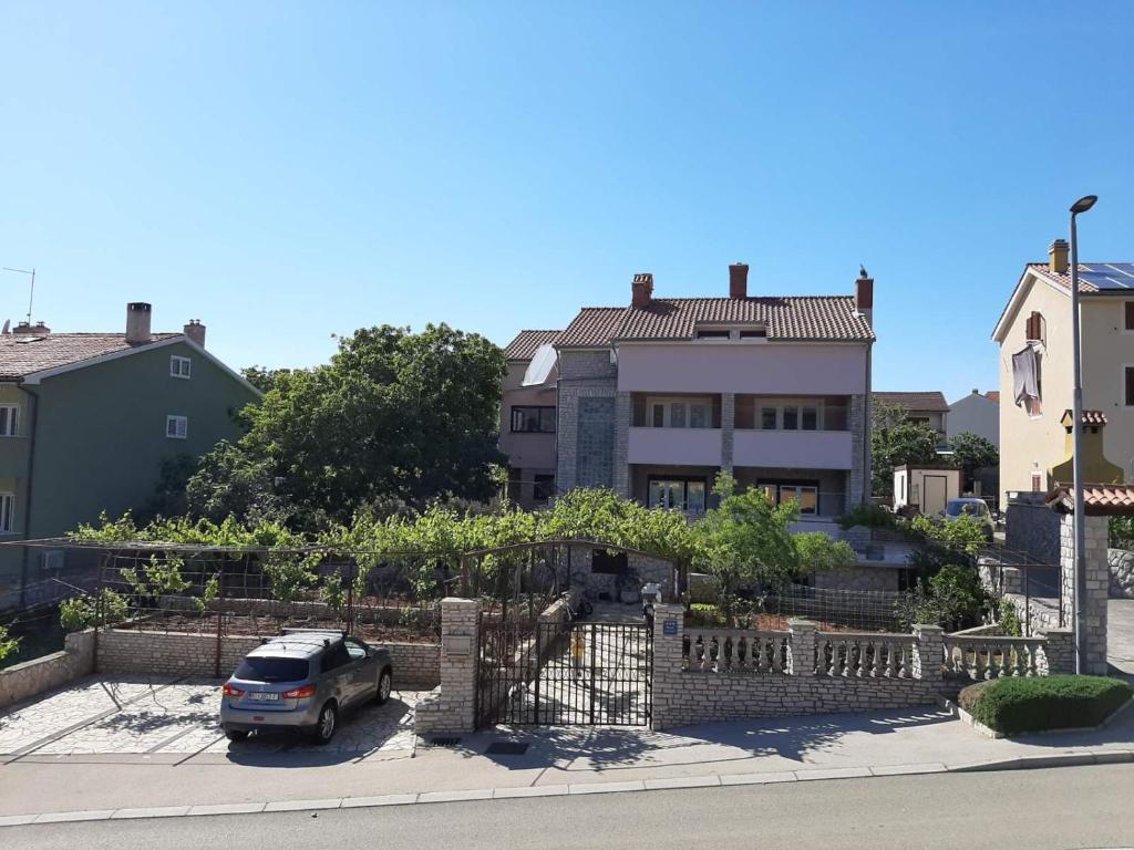 a car parked in front of a house at Apartments Mužić Cres II in Cres