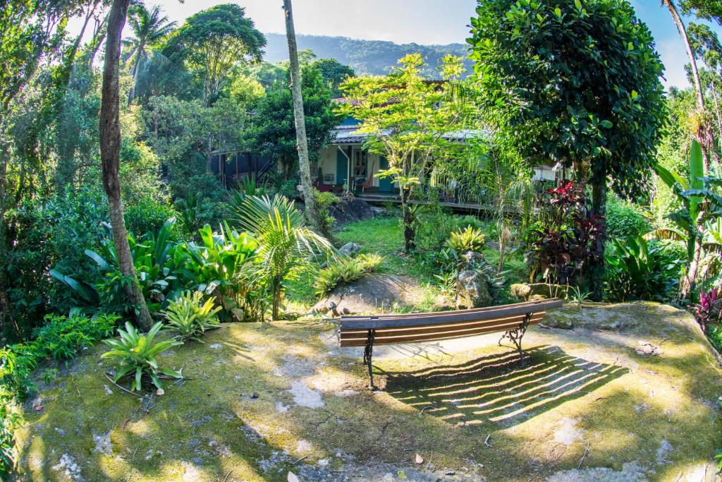 een parkbankje in het midden van een tuin bij Casa Grande Flats in Abraão
