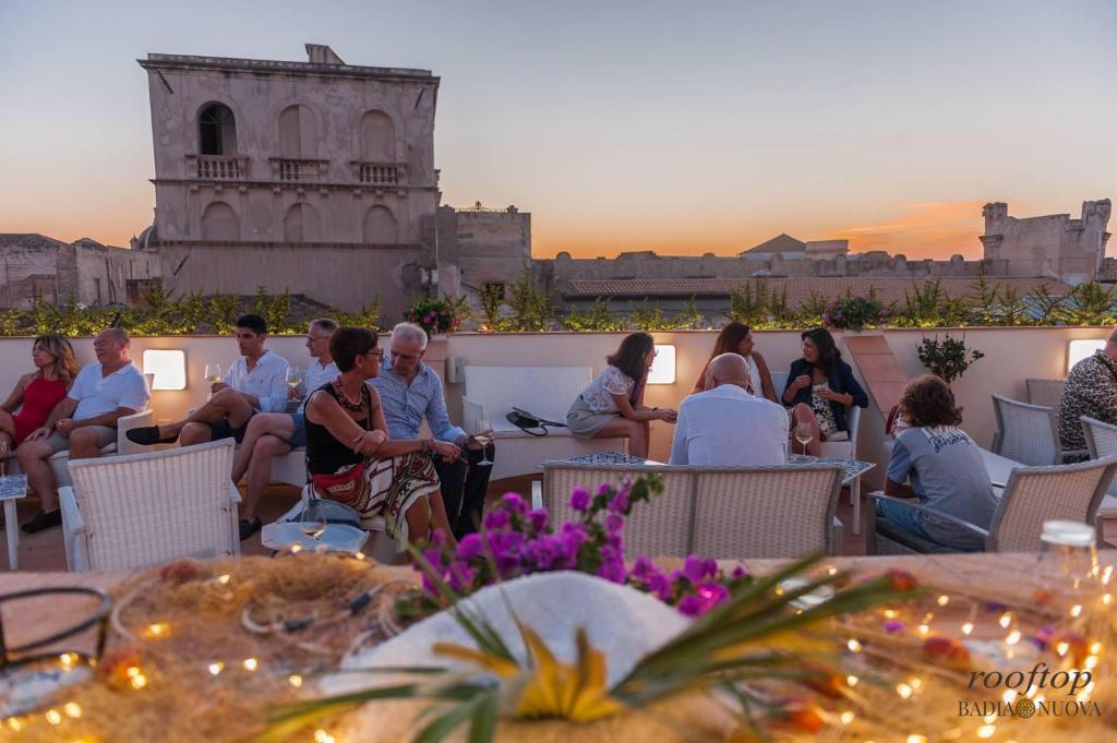 a group of people sitting on the roof of a building at BADIA NUOVA Apart Hotel in Trapani