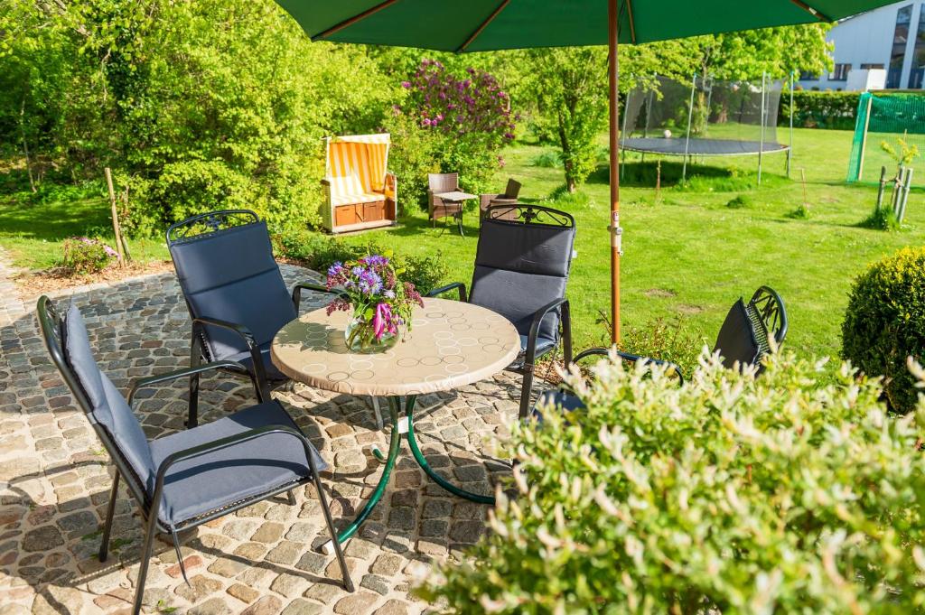 patio ze stołem, krzesłami i parasolem w obiekcie Haus Tilde w mieście Behrendorf
