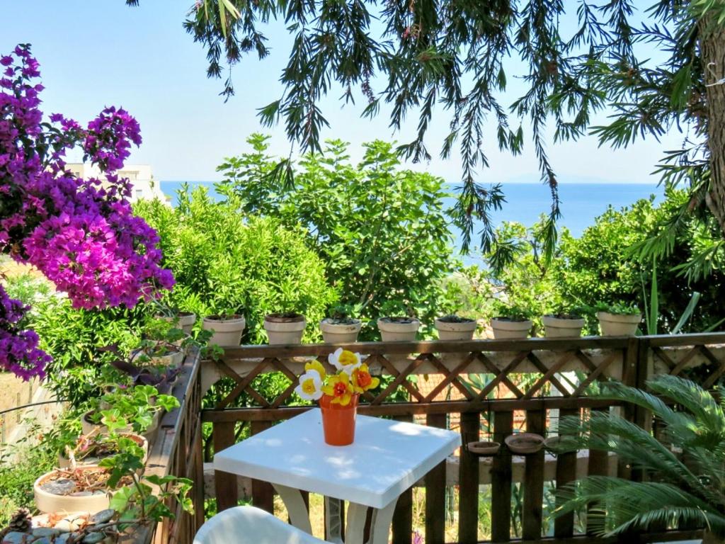 een tafel aan een hek met bloemen erop bij Maison de 2 chambres a Ville di Pietrabugno a 600 m de la plage avec vue sur la mer jardin clos et wifi in Toga