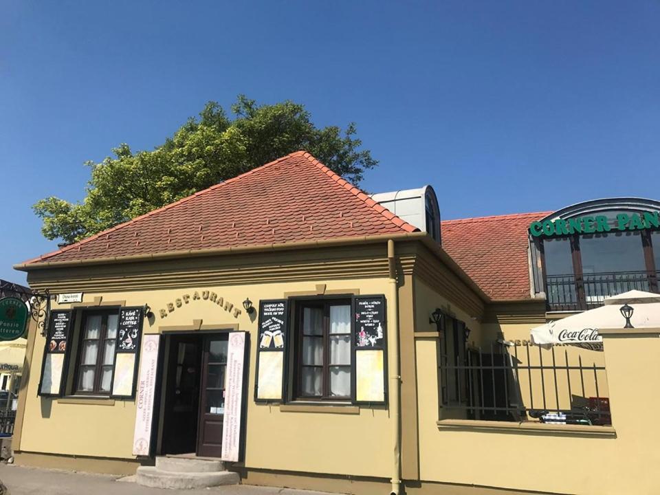 ein kleines gelbes Gebäude mit rotem Dach in der Unterkunft Corner Panzió in Szentendre