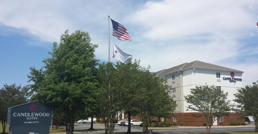 格林維爾的住宿－Candlewood Suites Greenville NC, an IHG Hotel，两面旗帜在建筑物前飞