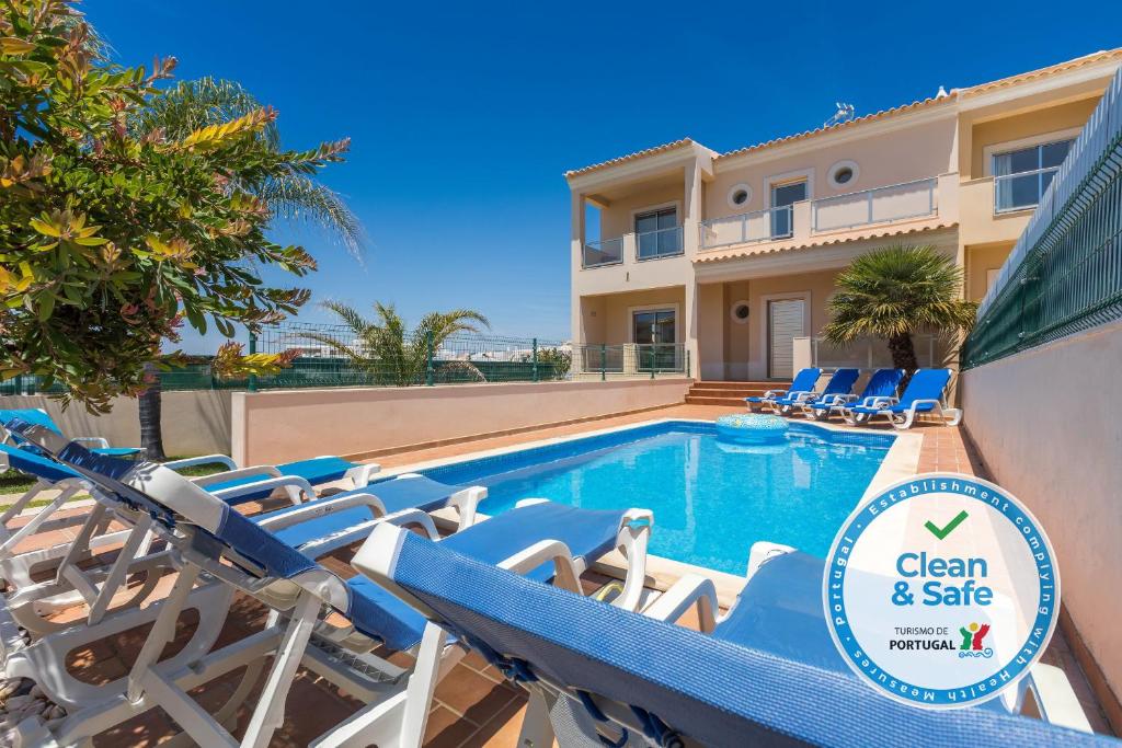 a villa with a swimming pool and lounge chairs at Moradia Ricardo - Praia da Gale in Albufeira