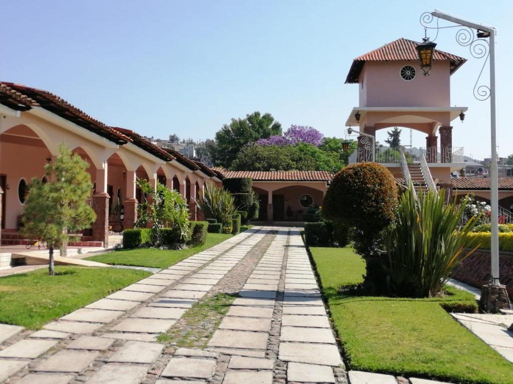 uma rua de calçada em frente a um edifício com uma torre de relógio em Hotel Ojo de Agua em Ciudad Hidalgo