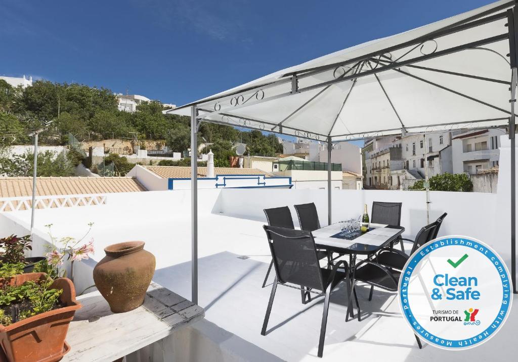 a patio with a table and an umbrella on a roof at DownTown Albufeira beach Apartment in Albufeira