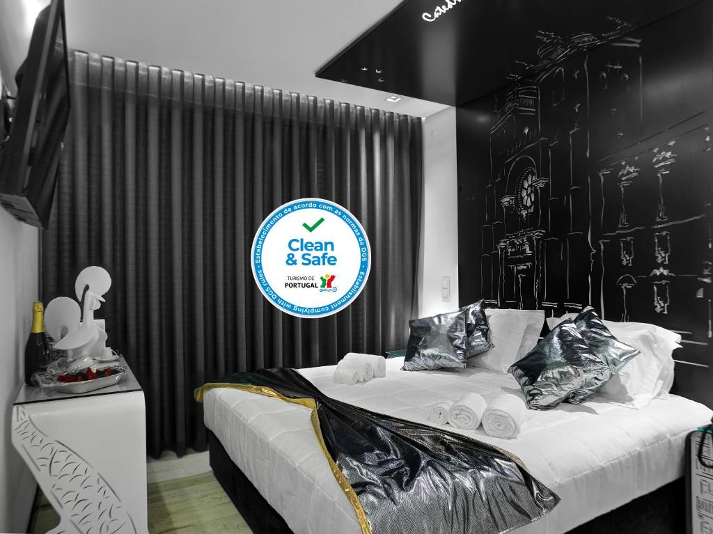 a black and white bedroom with a bed and a sign at Solar Antigo Porto Aeroporto in Maia