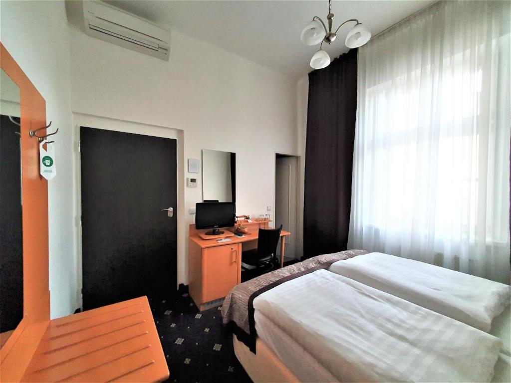 a bedroom with a bed and a desk and a television at Máchova in Prague