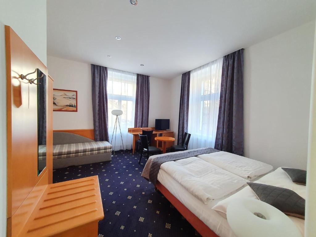 a hotel room with a bed and a desk at Máchova in Prague