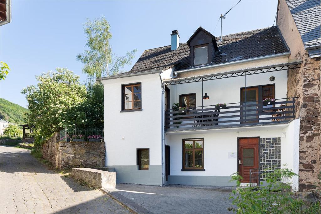 ein weißes Haus mit Balkon darüber in der Unterkunft Haus Junge Traube in Bruttig-Fankel