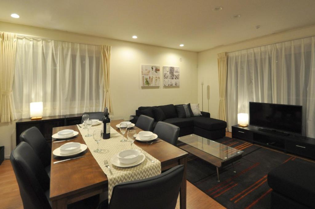 a living room with a table and a couch at Cat's Villa Hakuba 2- Vacation STAY 82203 in Hakuba