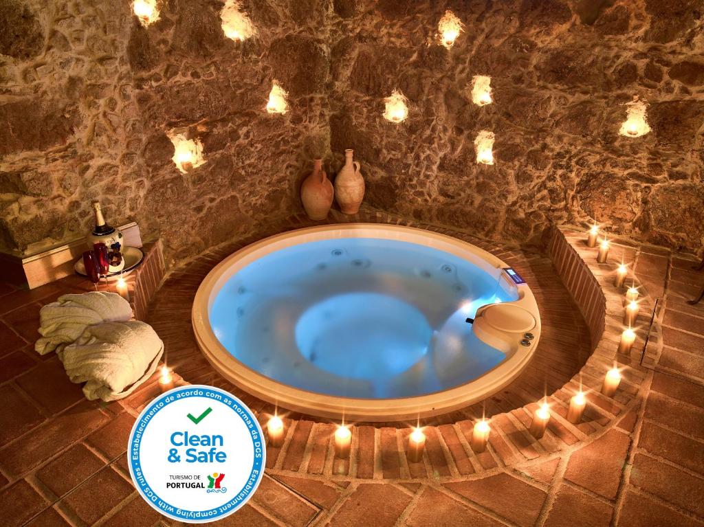 eine Whirlpool-Badewanne in einem Steinzimmer mit Beleuchtung in der Unterkunft Solar Antigo Luxury Spa Coimbra in Coimbra