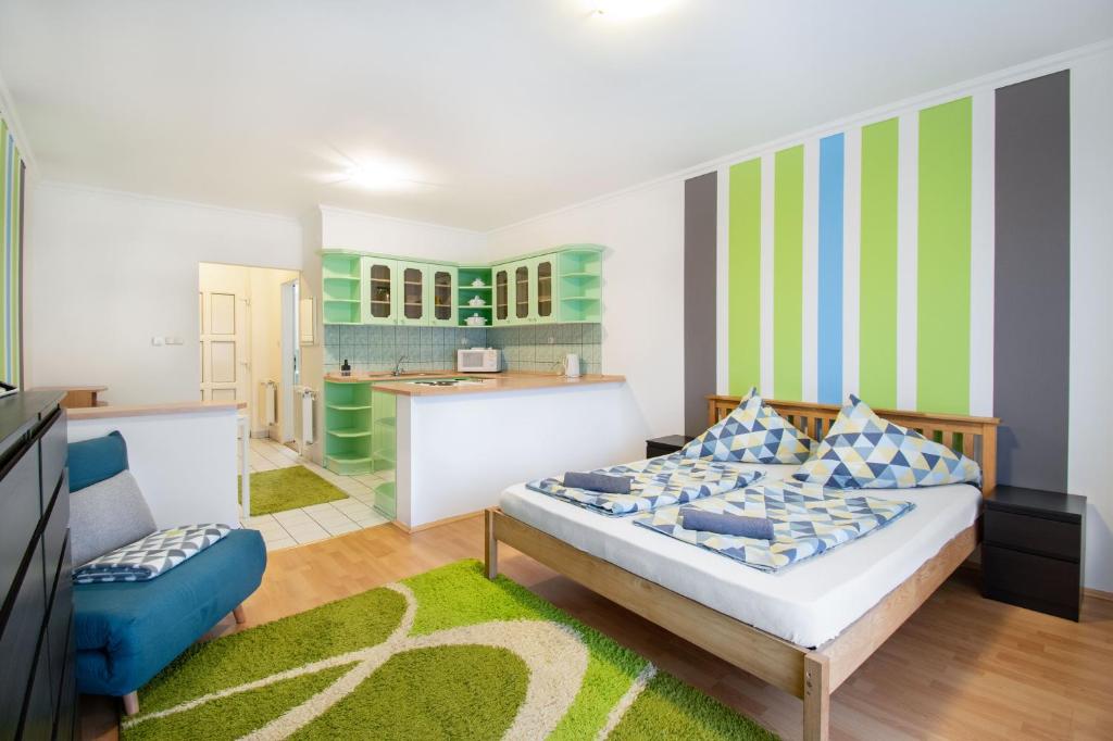 a bedroom with a bed and a kitchen at Lux Apartmanok in Hajdúszoboszló