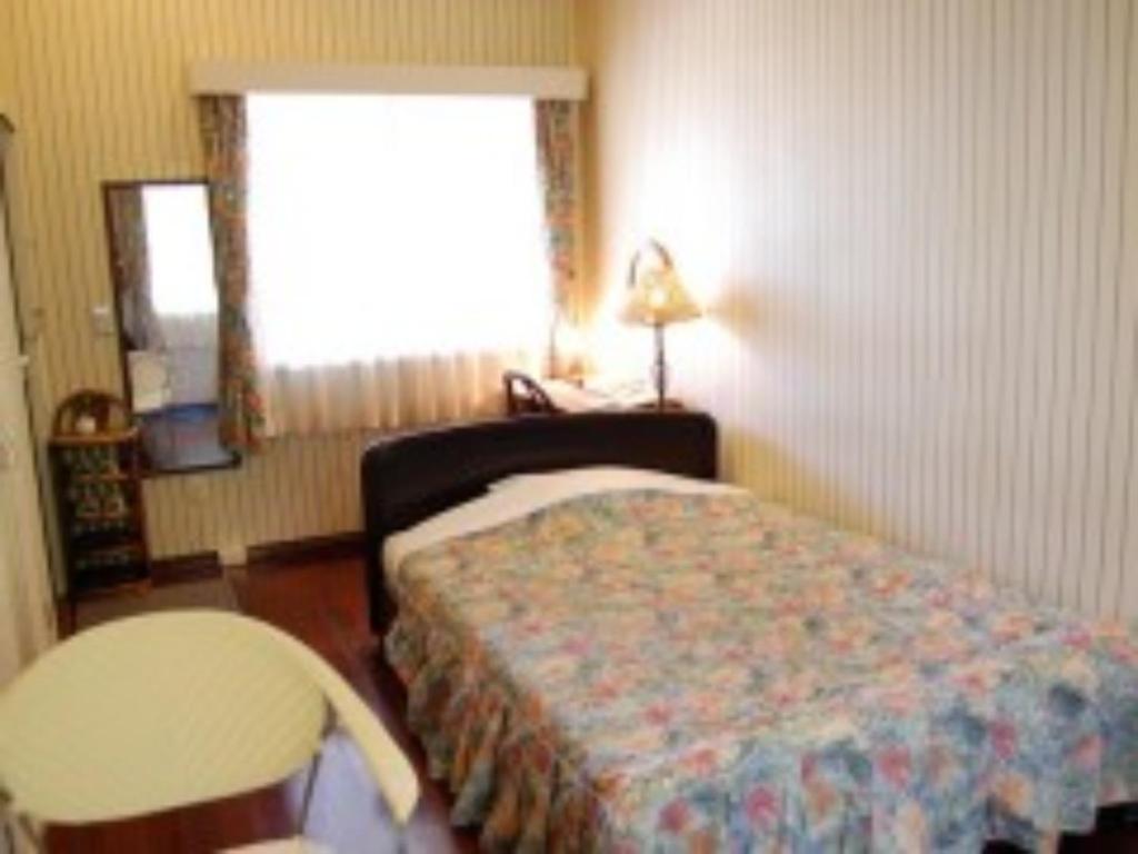 1 dormitorio con cama, mesa y ventana en Amami Resort Bashayamamura - Vacation STAY 81976, en Amami