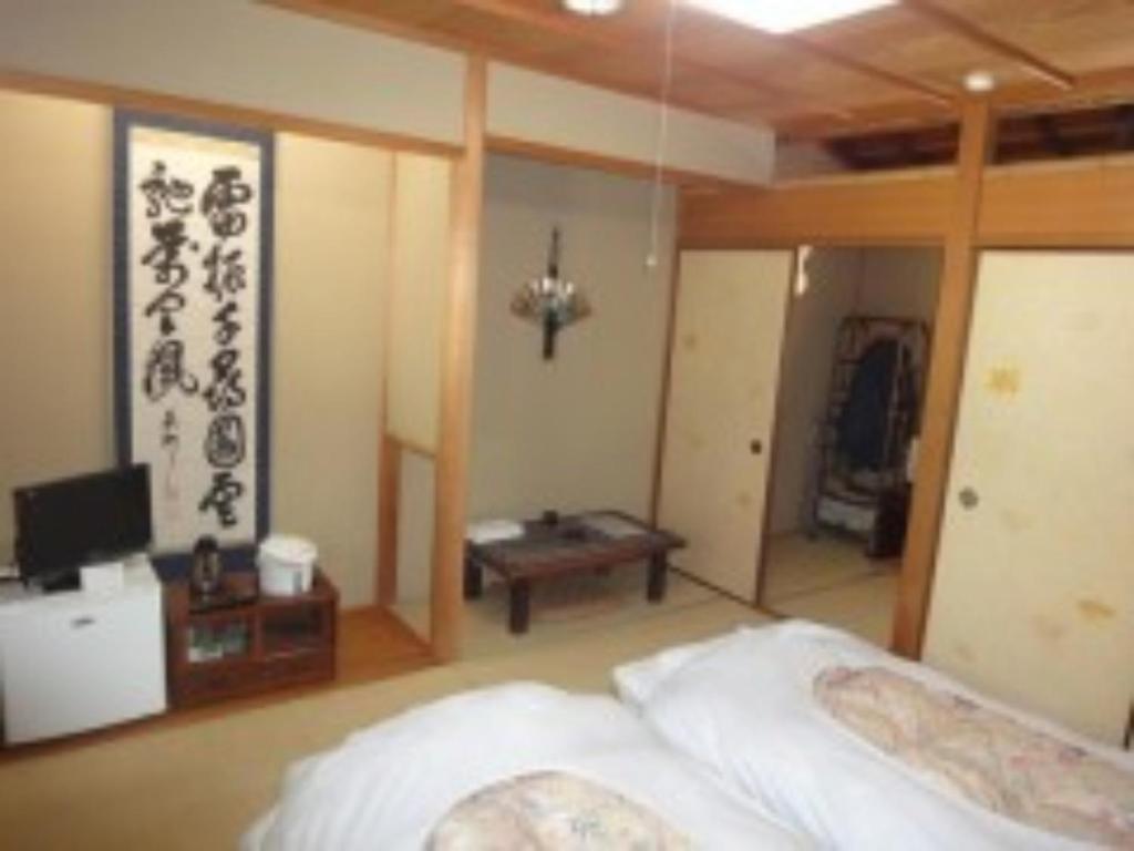ein Schlafzimmer mit einem Bett und einem TV. in der Unterkunft Amami Resort Bashayamamura - Vacation STAY 81973 in Amami
