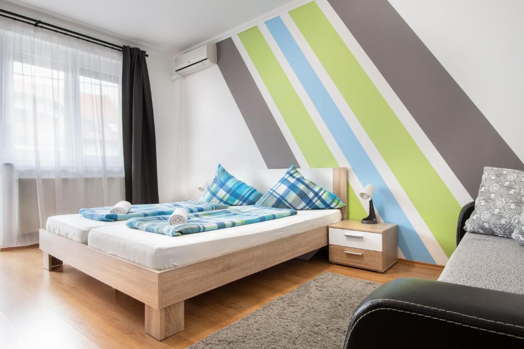 Un pat sau paturi într-o cameră la Lux Apartmanok