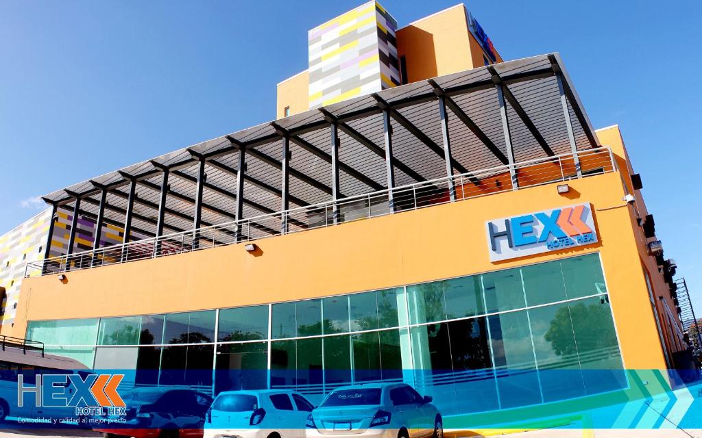 ein gelbes Gebäude mit davor geparkt in der Unterkunft Hotel Hex Estelí in Estelí