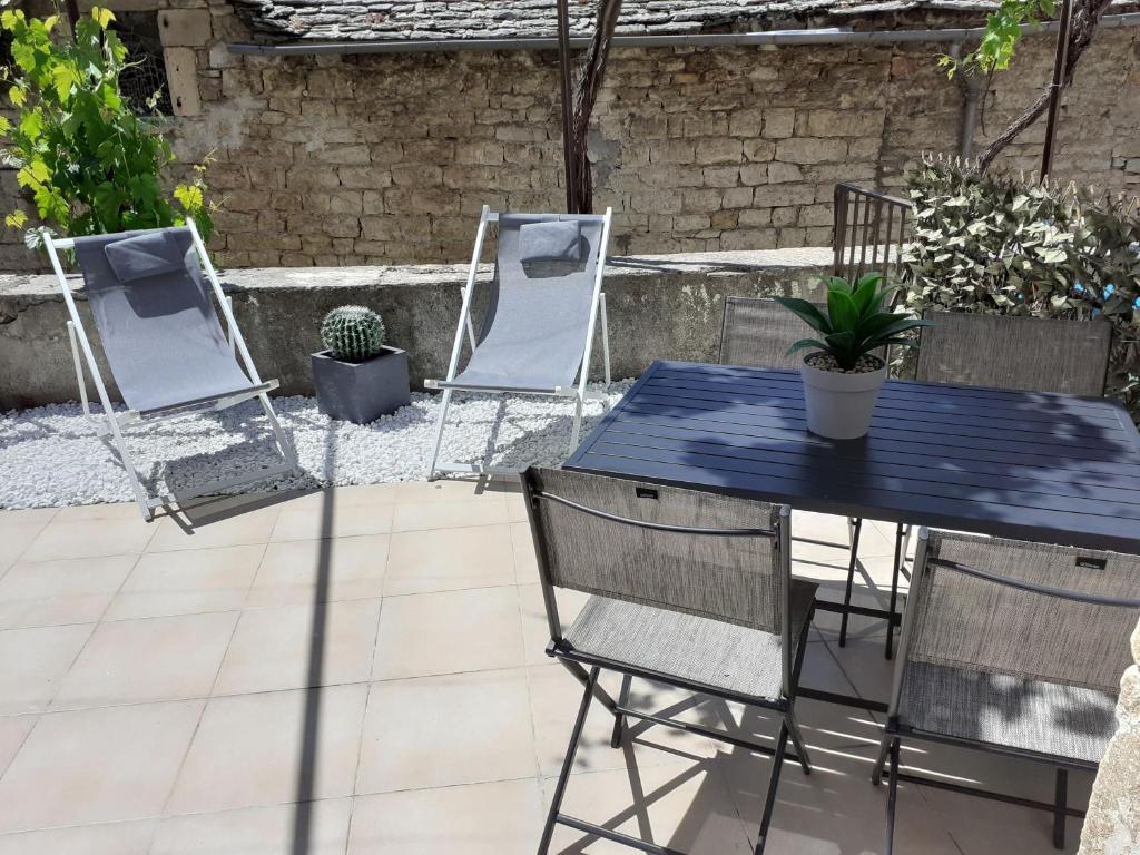 a blue table and chairs on a patio at LA PETITE MAISON D'ARNAL in Sainte-Énimie