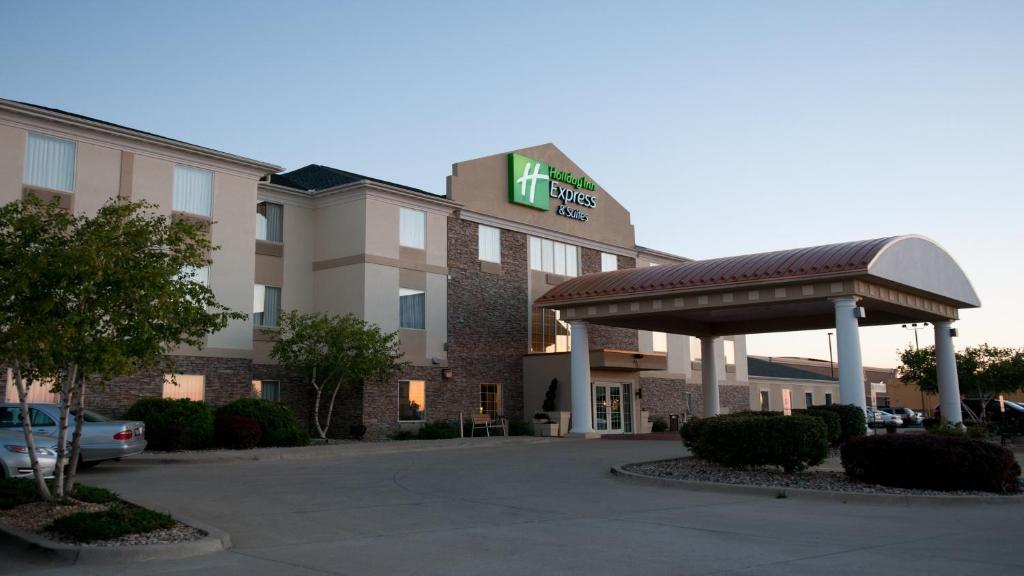 un hotel con aparcamiento frente a un edificio en Holiday Inn Express Hotel & Suites Bloomington-Normal University Area, an IHG Hotel en Bloomington