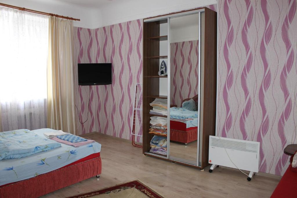 1 dormitorio con cama y espejo en Исторический центр en Chernihiv