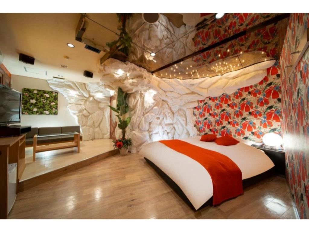 a bedroom with a bed and a stone wall at Royal Hotel Uohachi Bettei - Vacation STAY 81417 in Ogaki