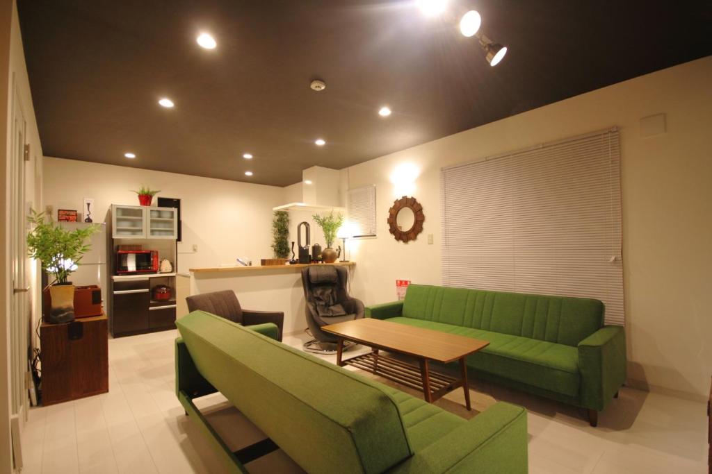 - un salon avec un canapé vert et une table dans l'établissement Minamitsuru-gun - House - Vacation STAY 82298, à Fujikawaguchiko