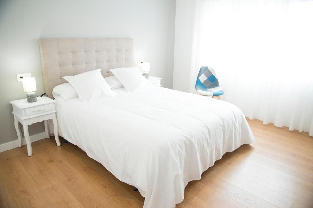 A bed or beds in a room at L2 Apartamento O Grove Centro 2 hab con Aire Ac Parking