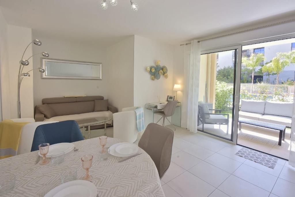- un salon avec une table, des chaises et un canapé dans l'établissement Palm Beach - swimming pool - beach at few steps, à Cannes