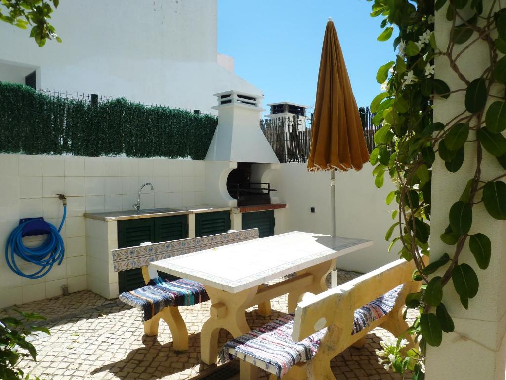 a kitchen with a table and two chairs and an umbrella at 2 bedrooms house at Vila Nova de Cacela 300 m away from the beach with enclosed garden and wifi in Vila Nova De Cacela