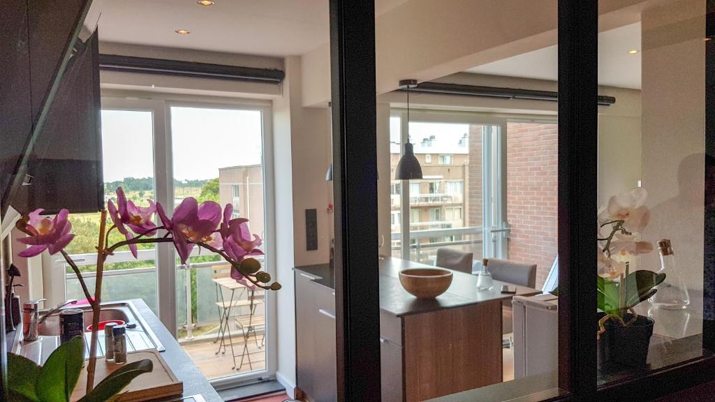 een keuken met een grote glazen deur en een balkon bij Cocoon in East-Brussels in Wezembeek-Oppem