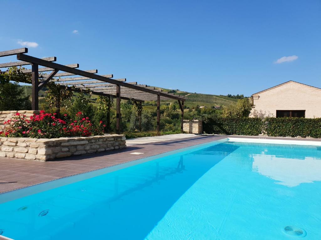 una piscina azul con pérgola de madera en One bedroom appartement with shared pool and wifi at Montalto delle Marche, en Montalto delle Marche