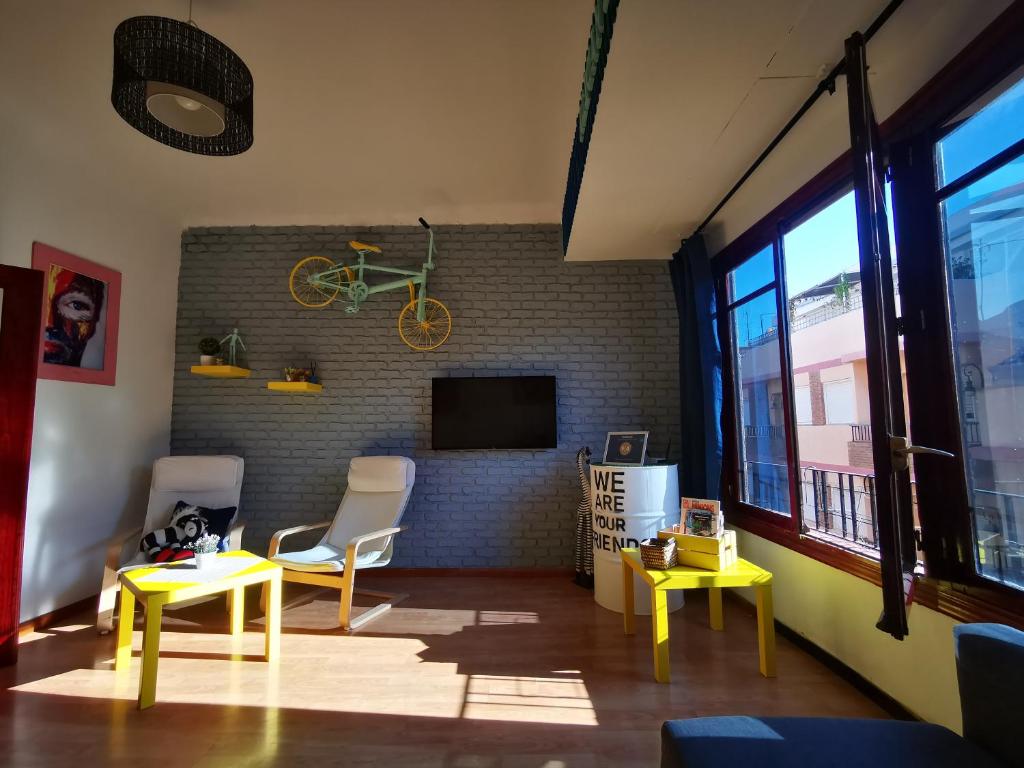 una sala de estar con 2 mesas y una bicicleta colgada en una pared de ladrillo en GINGER apartment, en Alicante