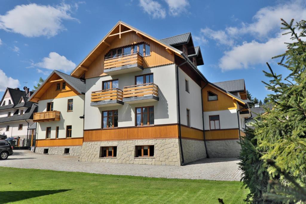 a large white building with a wooden roof at Willa Cicha in Zakopane