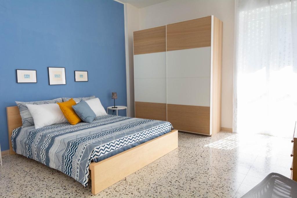1 dormitorio con cama y pared azul en Gaia14, en Salerno