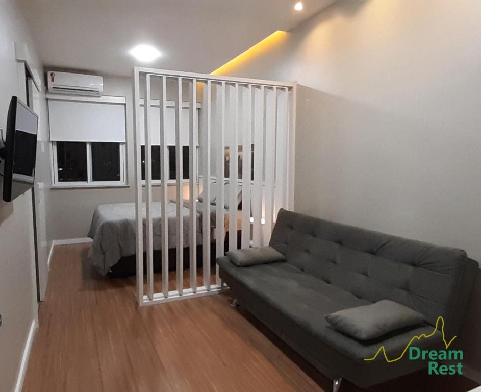 uma sala de estar com um sofá e uma cama em Loft Dream Rest em Teresópolis